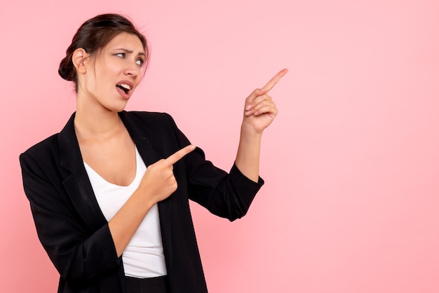 Front view young female in dark jacket talking to someone on pink background