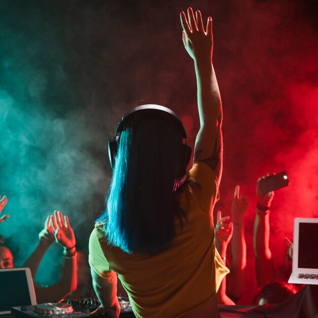 Front view young female dj entertaining crowd