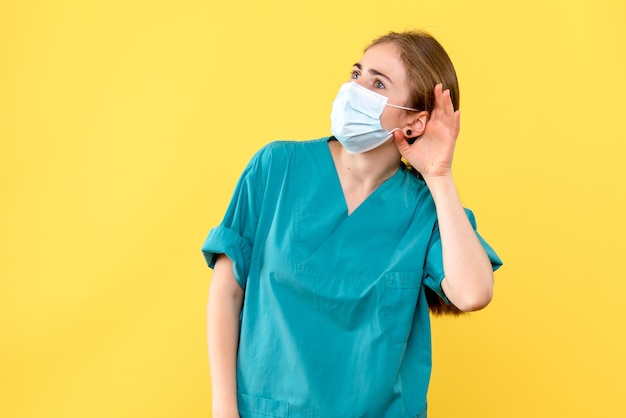 Front view of young female doctor listening