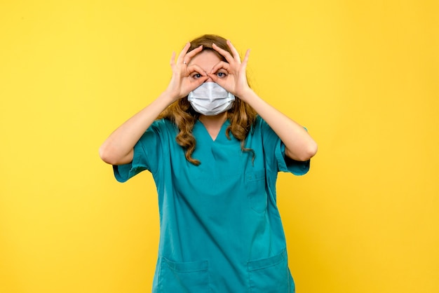 노란색 공간에 마스크에 전면보기 젊은 여성 의사