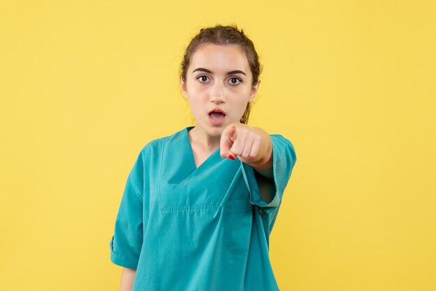 Front view young female doctor in medical suit on yellow background