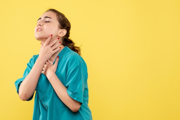 Front view young female doctor in medical suit on yellow background