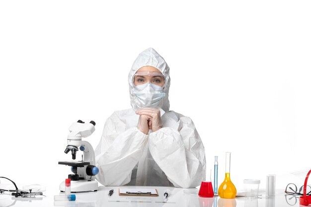 Вид спереди молодая женщина-врач в защитном костюме с маской из-за covid на светлом белом фоне болезнь здоровья пандемический вирус covid