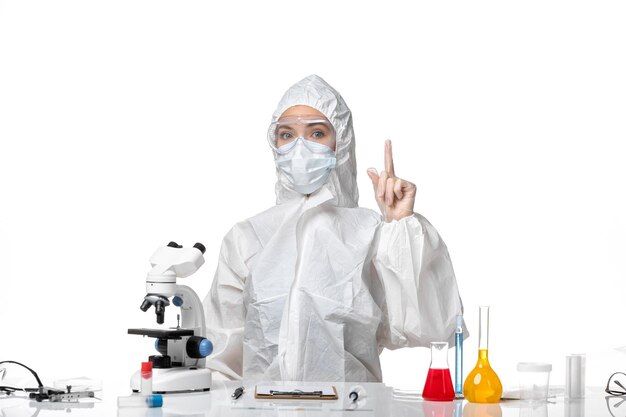 Front view young female doctor in protective suit with mask due to covid on white background disease health pandemic covid virus