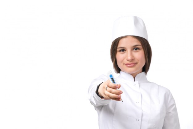 A front view young female doctor in white medical suit and white cap 