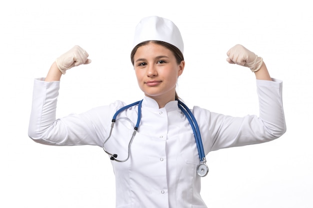 파란색 청진 장갑을 착용하고 구부리기와 흰색 의료 소송에서 전면보기 젊은 여성 의사