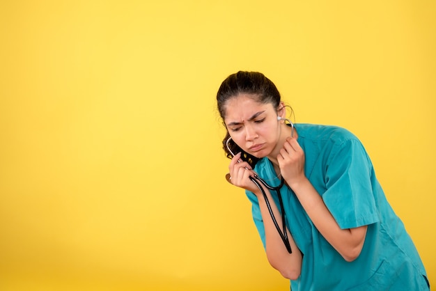 Free photo front view of young female doctor with stethoscope on yellow wall