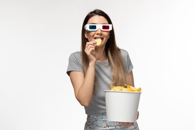 Front view young female eating cips while watching movie in d sunglasses on the white surface