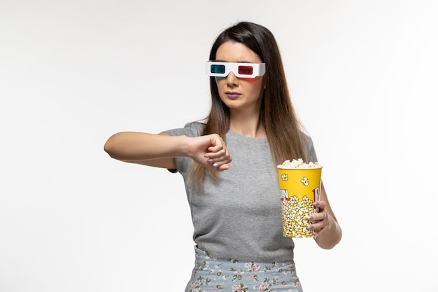 팝콘을 먹고 흰색 표면에 d 선글라스로 영화를 보는 전면보기 젊은 여성