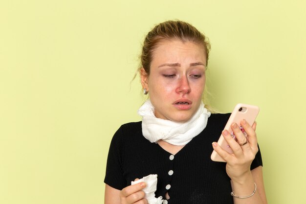 Front view young female feeling very ill and sick talking on the phone on the green wall female sickness medicine illness