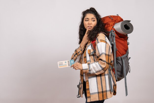 Front view young female going in hiking holding ticket on the white background trip tourist vacation flight campus air mountain forest