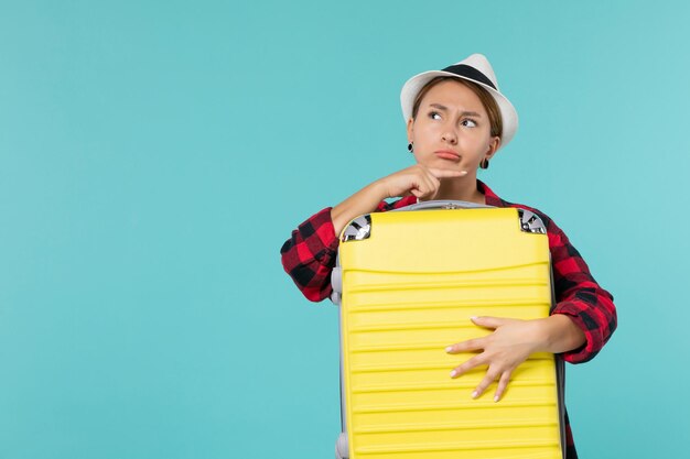 Front view young female going in vacation with her big bag on a blue space