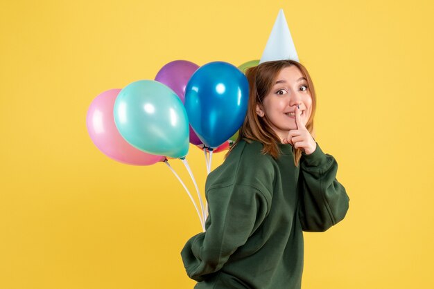 Front view young female hiding colorful balloons behind her back