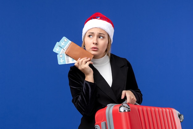 Foto gratuita giovane borsa e biglietti femminili della tenuta di vista frontale sulla vacanza di festa dell'aereo dello scrittorio blu