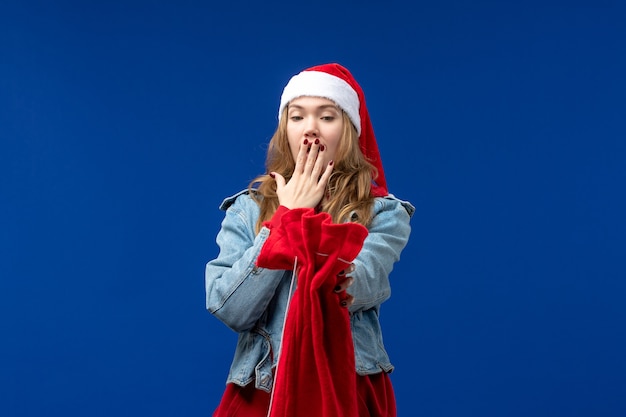 Foto gratuita vista frontale giovane femmina che tiene borsa con regali su sfondo blu vacanze natale emozioni