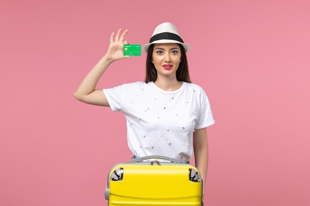 Front view young female holding bank card on a pink wall summer trip emotion woman