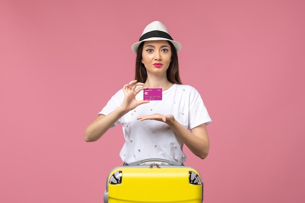 분홍색 벽 여행 여자 휴가 돈에 은행 카드를 들고 전면 보기 젊은 여성