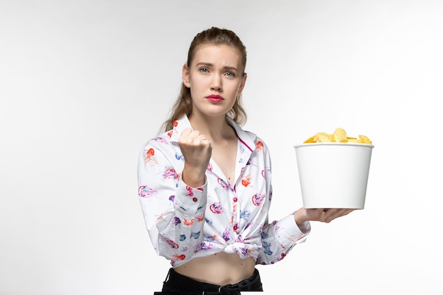 Front view young female holding basket with chips on white surface