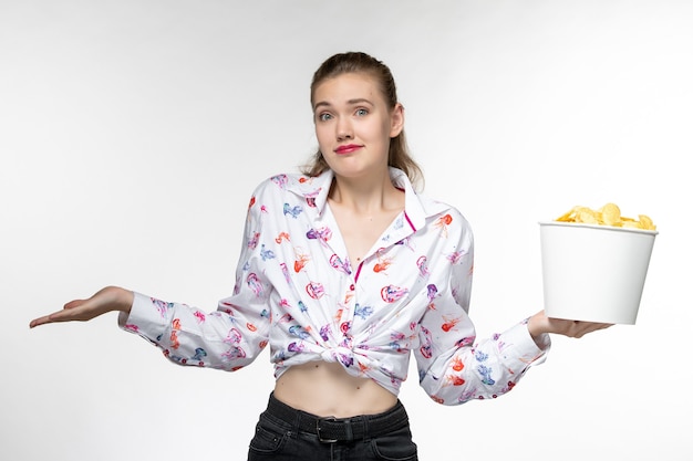 Front view young female holding basket with chips on white surface