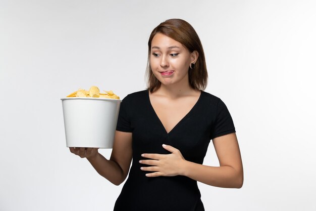 Front view young female holding basket with chips on white surface