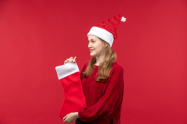 Front view young female holding big christmas sock, holidays red woman