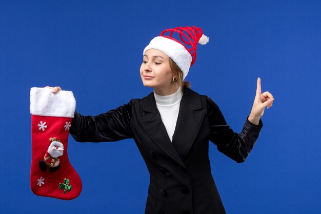 水色の壁の大晦日休日に大きなクリスマス靴下を保持している正面図若い女性