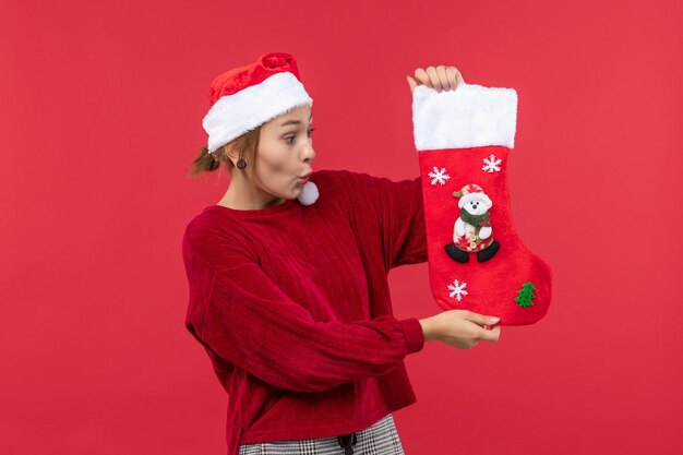大きなクリスマス靴下、赤いクリスマス休暇を保持している若い女性の正面図