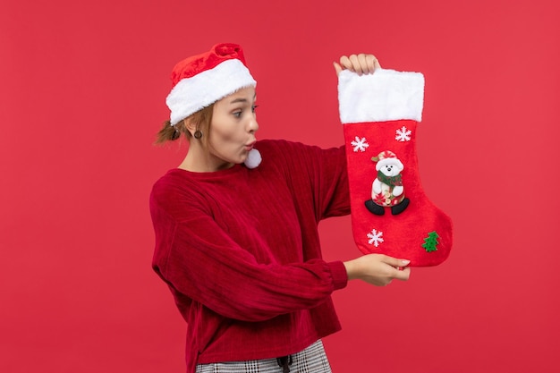 Front view young female holding big christmas sock, red christmas holiday