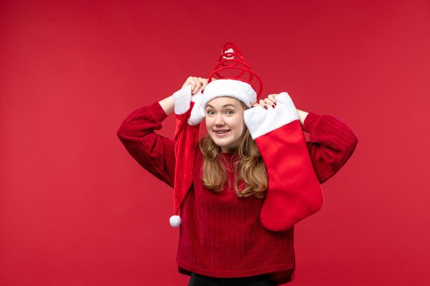 大きな靴下とキャップ、休日のクリスマスを保持している若い女性の正面図