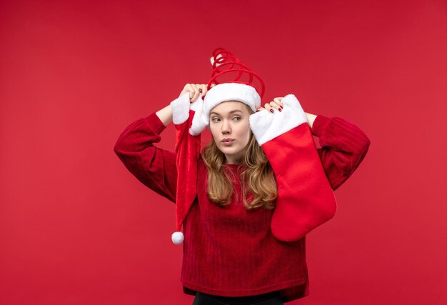 Front view young female holding big sock and cap, holidays christmas