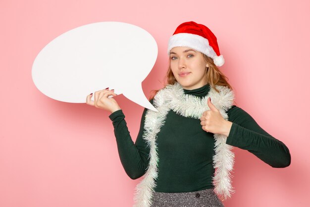 Front view young female holding big white sign on pink wall christmas new year model holiday colors emotion