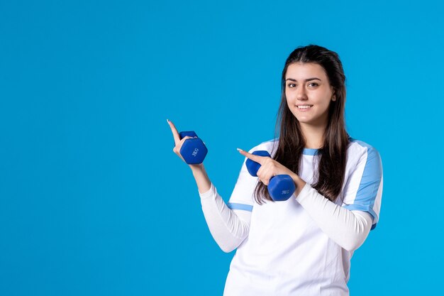 Front view young female holding blue dumbbells