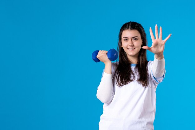 Front view young female holding blue dumbbells