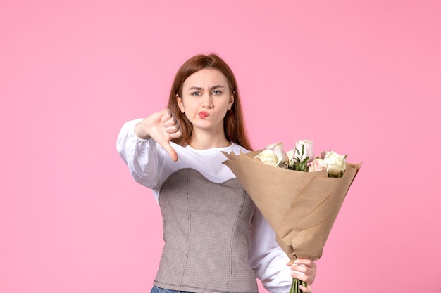 분홍색에 아름 다운 장미 꽃다발을 들고 전면 보기 젊은 여성