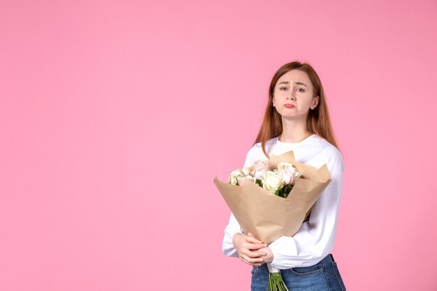 Front view young female holding bouquet of beautiful roses on pink