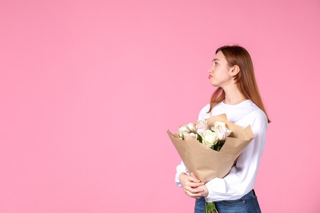 ピンクの美しいバラの花束を保持している正面図若い女性