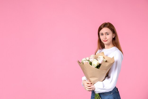ピンクの美しいバラの花束を保持している正面図若い女性