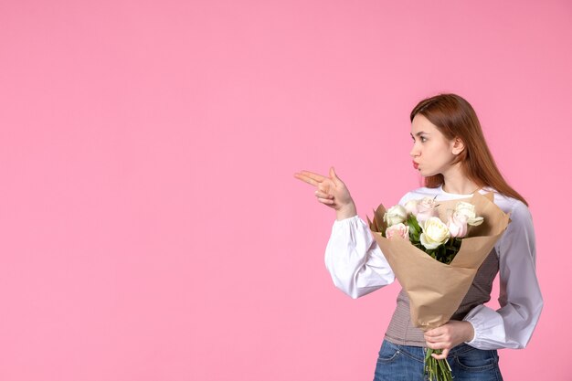 ピンクの美しいバラの花束を保持している正面図若い女性