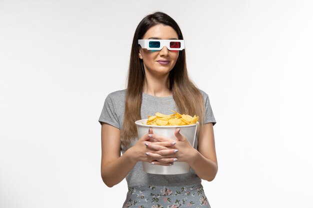 Front view young female holding chips and watching movie in d sunglasses on the white surface