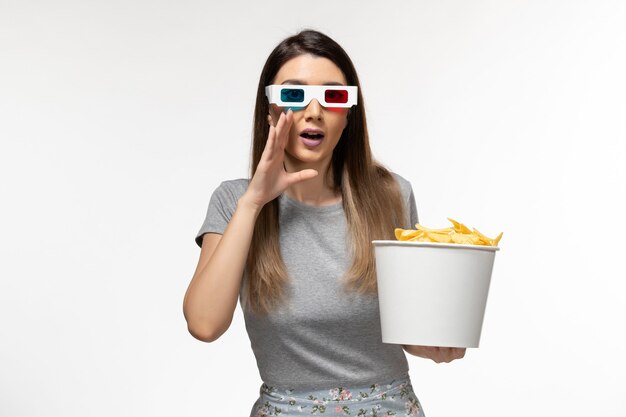 Front view young female holding chips and watching movie in d sunglasses on white surface