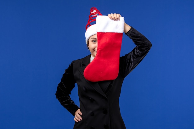 Free photo front view young female holding christmas sock on blue desk holiday woman new year