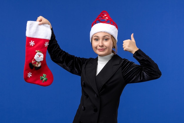 Front view young female holding christmas sock on blue floor new year woman holiday