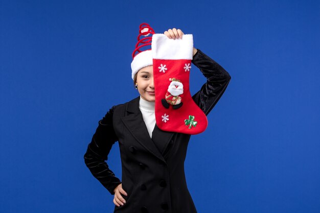 Front view young female holding christmas sock on blue floor woman holiday new year