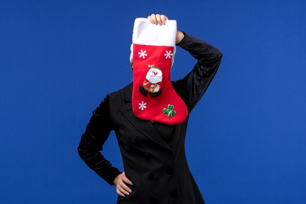 Front view young female holding christmas sock on blue wall holiday woman new year