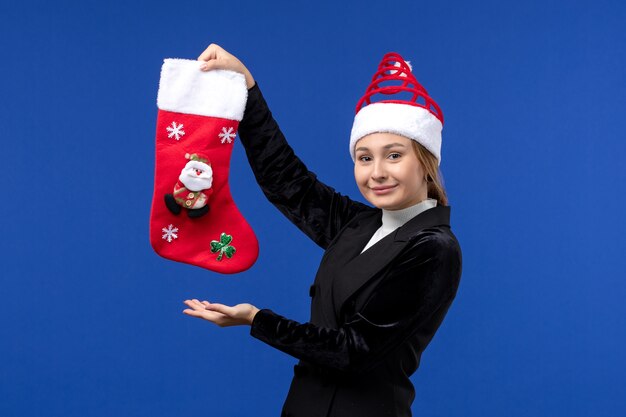 正面図青い壁にクリスマス靴下を保持している若い女性新年の女性の休日
