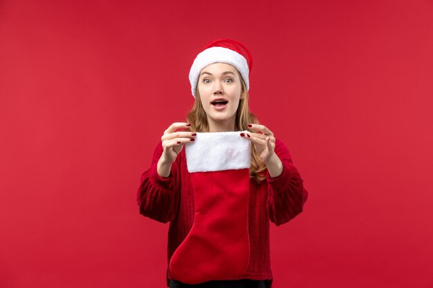 Front view young female holding christmas sock on red desk holiday red woman