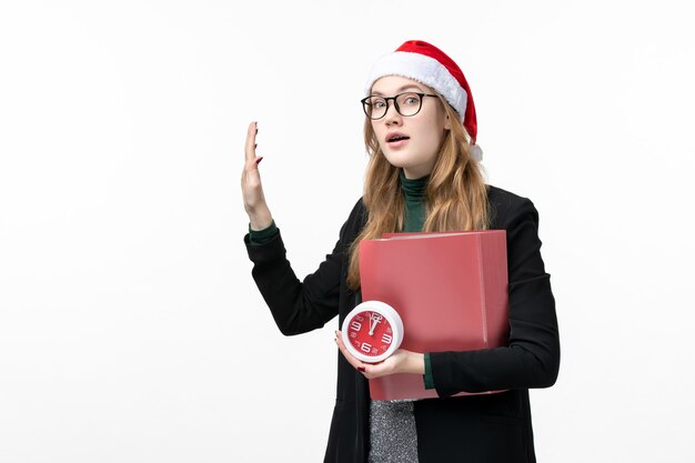 Front view young female holding clock and files on white floor lesson college book