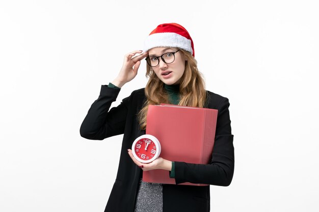 Front view young female holding clock and files on the white wall book lesson college