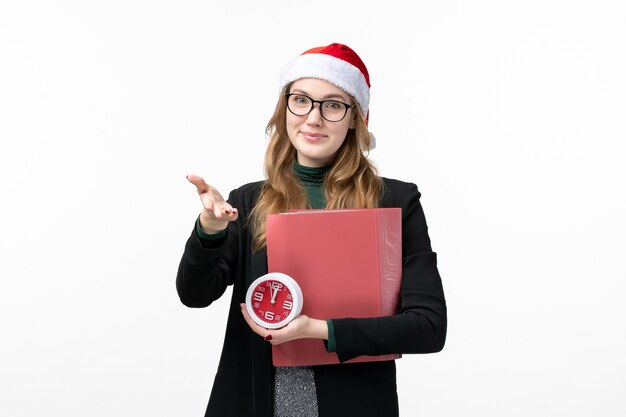 Front view young female holding clock and files on white wall college book lesson