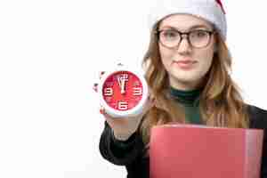 Free photo front view young female holding clock and files on white wall lesson college books